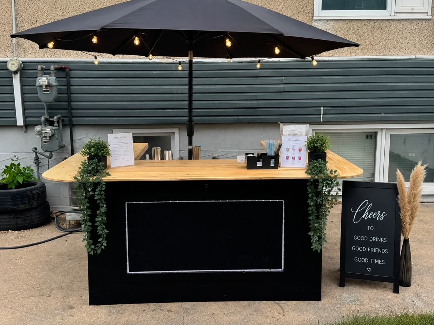 Black-and-wood pop-up bar with umbrella, styled for an event